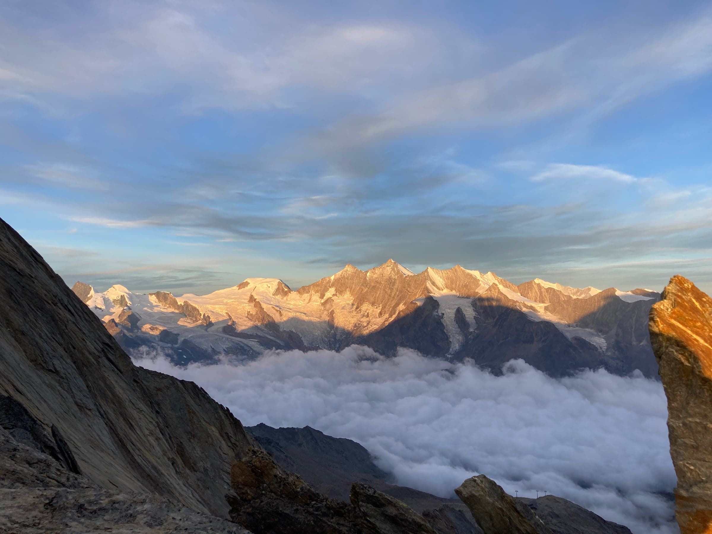 Sommets enneigés au coucher du soleil avec mer de nuages dans les Alpes suisses